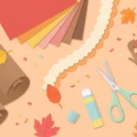 Pastel desk scene with brown background paper, scissors, glue, colored pencils and paper leaves on soft peach.